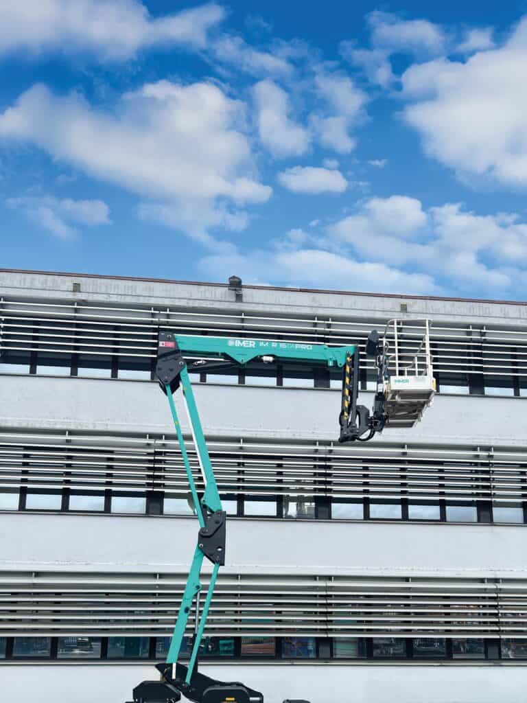 IM R 49 / 15 DA Pro set up on outriggers beside a stadium facade